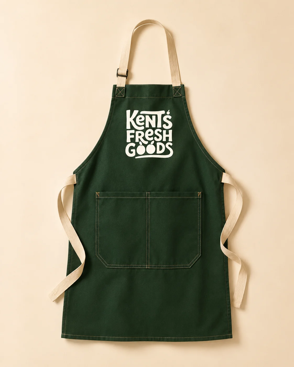 Kent's Fresh Goods forest-green staff apron with the reversed logo